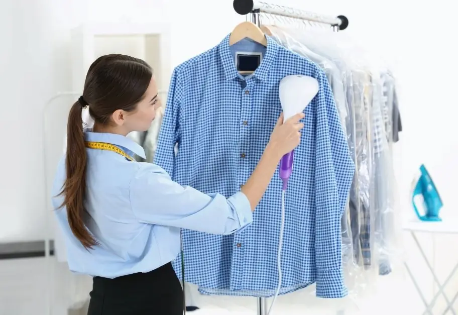 Professional pressing a garment at Impeccable Plus